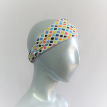 Load image into Gallery viewer, Head band with sqares of yellow, orange, blue and black . All on a white back ground. Back neck has a one inch elastic covered in the same fabric. Beach lovers will love this.