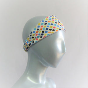 Head band with sqares of yellow, orange, blue and black . All on a white back ground. Back neck has a one inch elastic covered in the same fabric. Beach lovers will love this.