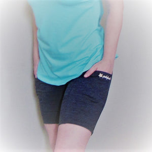 Grey black heather bike shorts on a model. High waisted and the hands are in the pockets to  show the size. The length of the shorts is mid thigh.