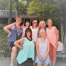 Load image into Gallery viewer, A group of women wearing sleeveless tank tops with heart designs on the front, posing outdoors.